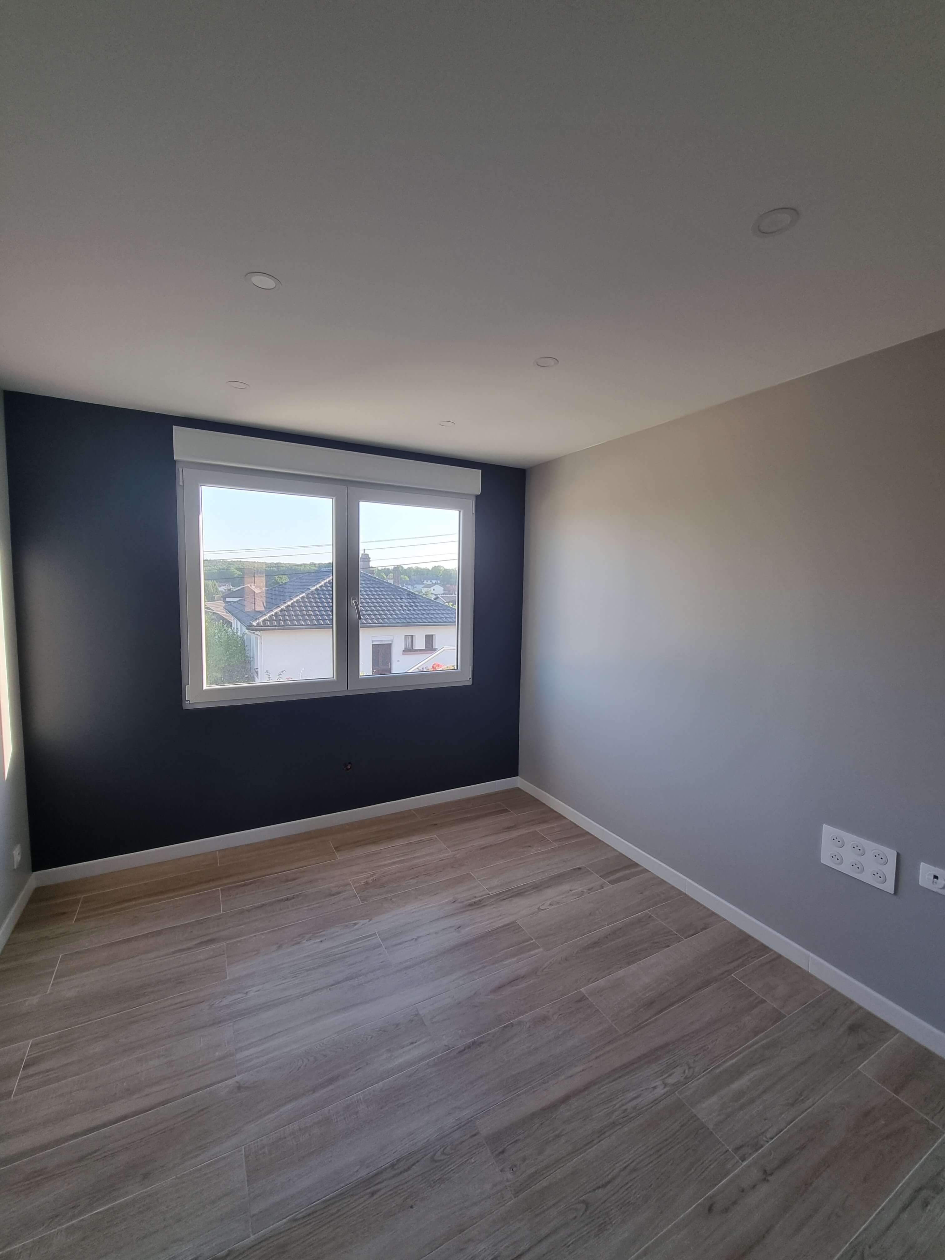 Chambre livrée, mur bleu nuit et carrelage grand format effet bois